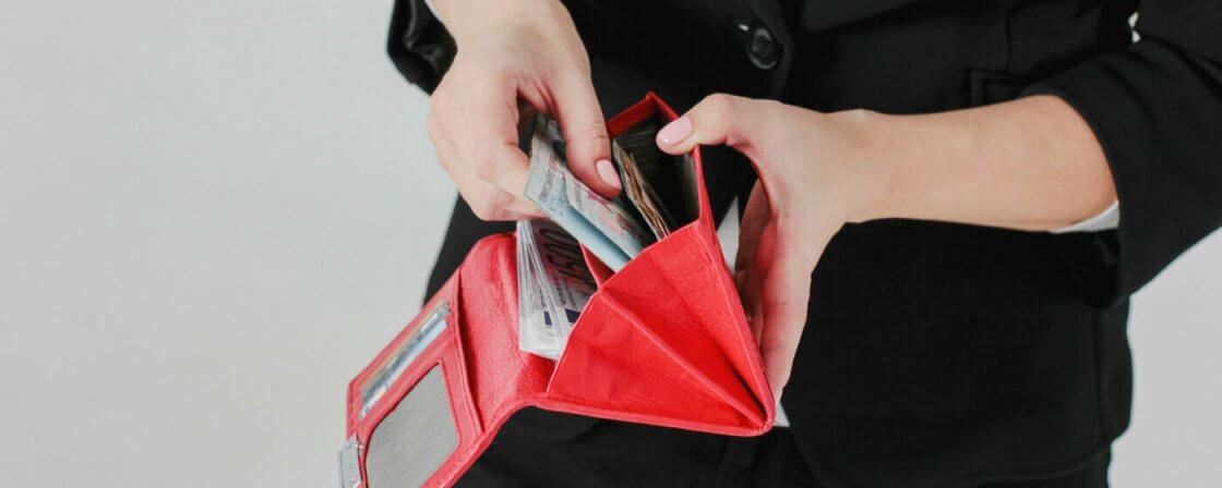žena vytahuje bankovky z peněženky, vracení bezdůvodného obohacení