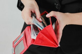 žena vytahuje bankovky z peněženky, vracení bezdůvodného obohacení