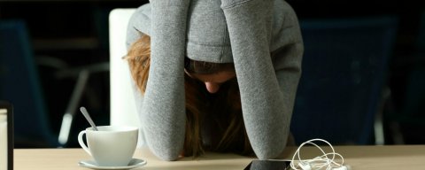 Nešťastná žena s hlavou v dlaních, diskriminace na pracovišti