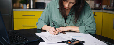 žena počítající příjmy a výdaje, zaručená mzda
