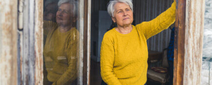 darování nemovitosti, stará žena se dívá z okna