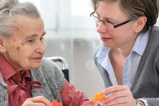 Starší paní a důchodkyně si povídají u stolu