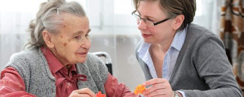 Starší paní a důchodkyně si povídají u stolu