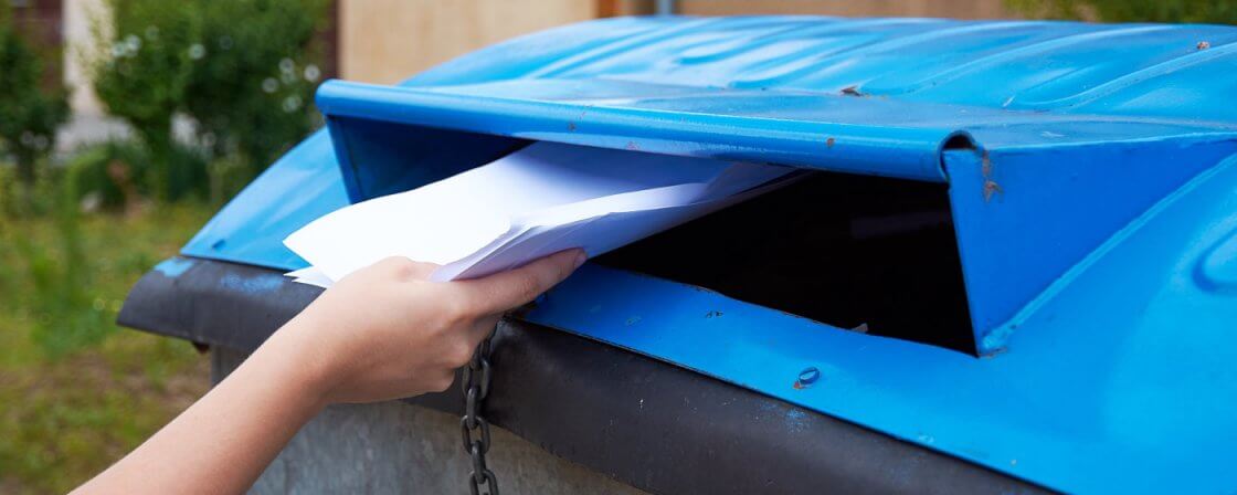 ruce házející dokumenty do popelnice