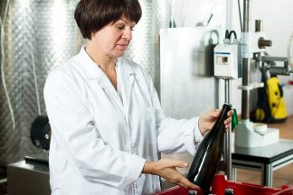 Žena ve výrobě rovná láhve od vína