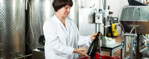 Žena ve výrobě rovná láhve od vína