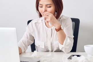 Žena sedící za počítačem u pracovního stolu